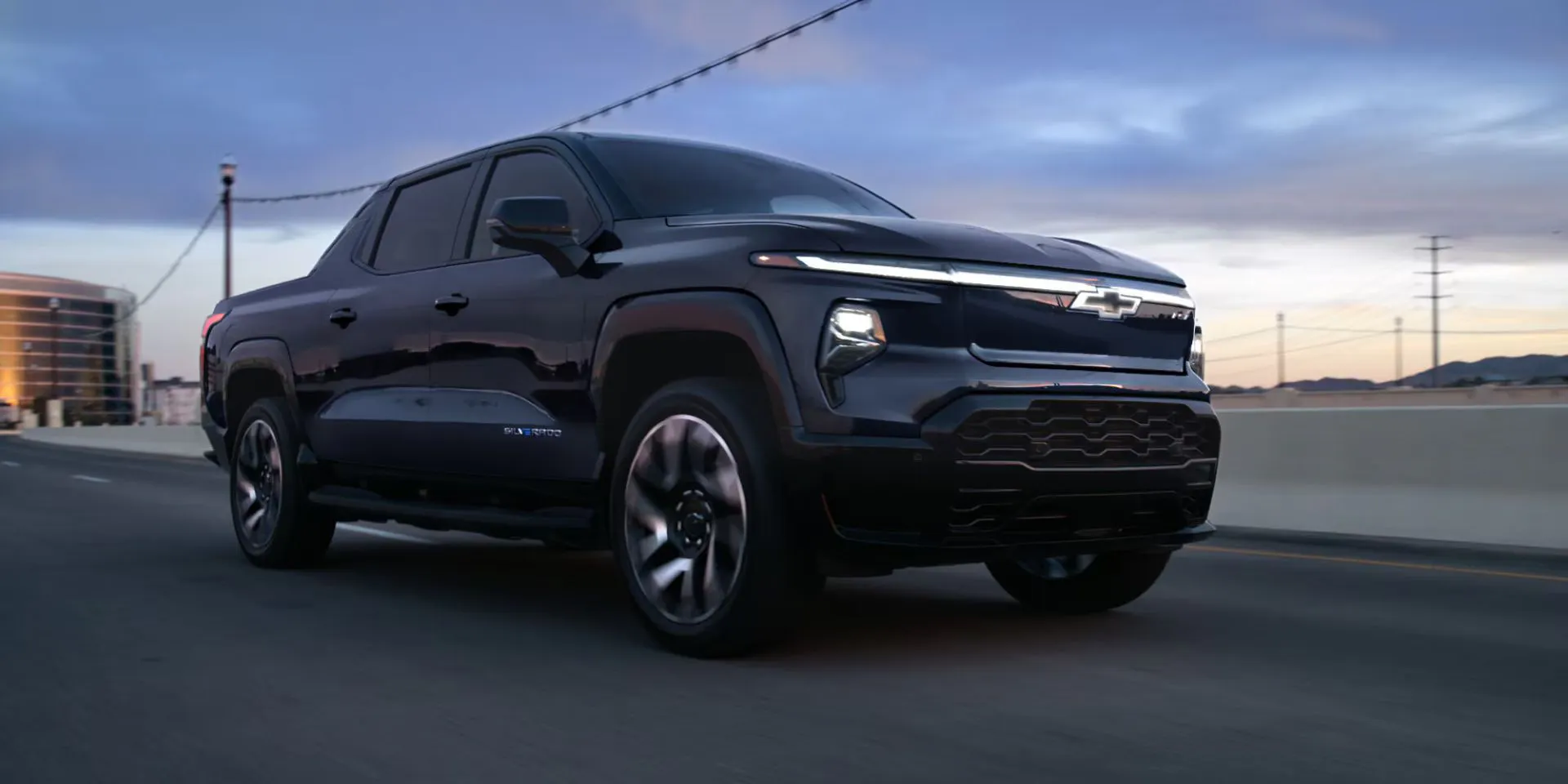 A black truck driving on the road.