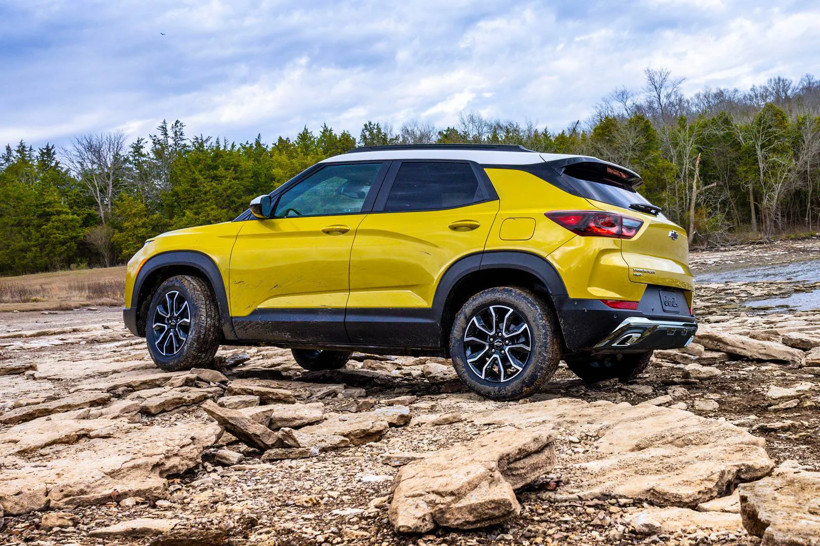A yellow trailblazer sitting off-road.