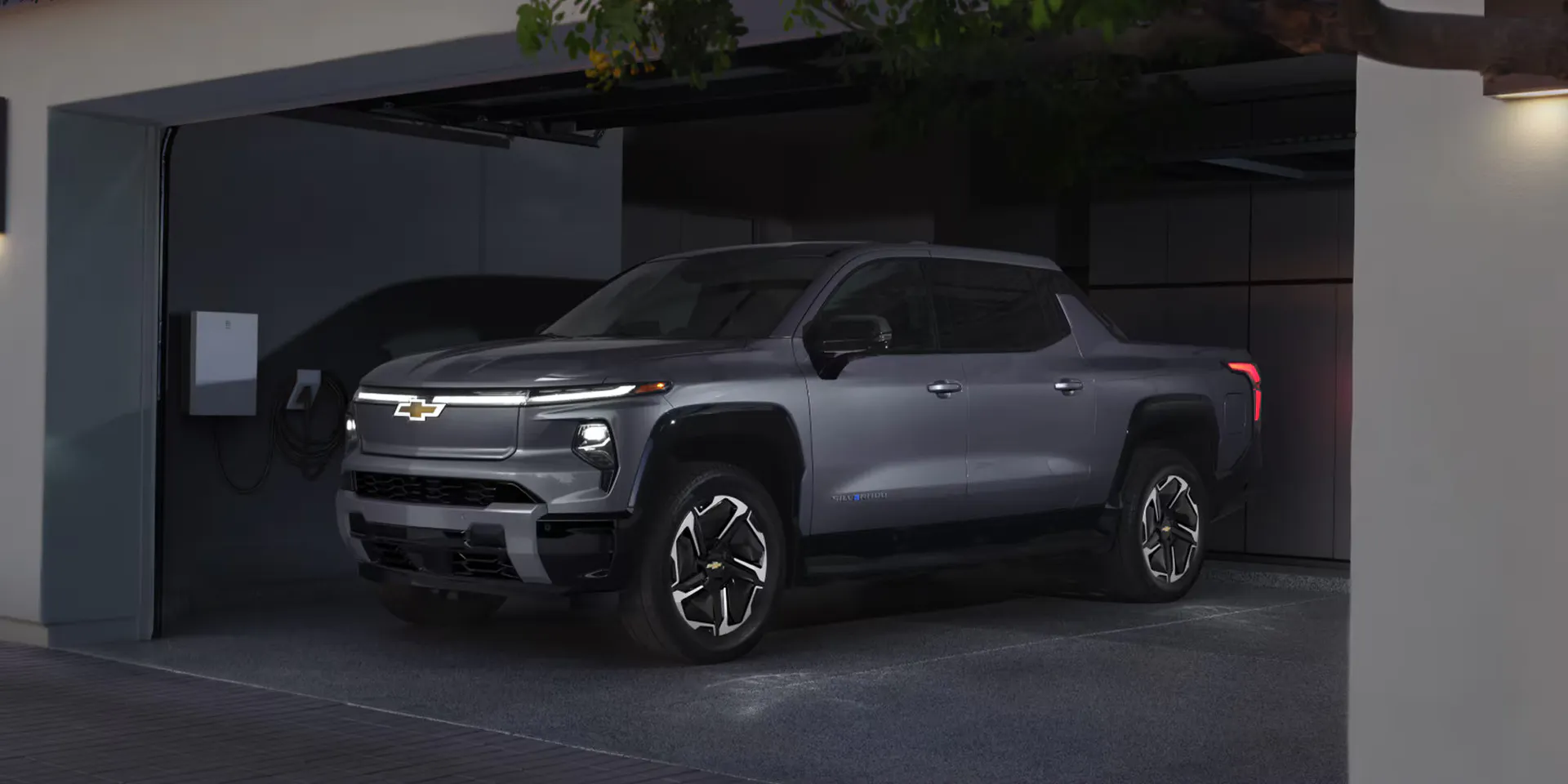 a view of the new 2026 chevy silverado ev parked at home next to a charger