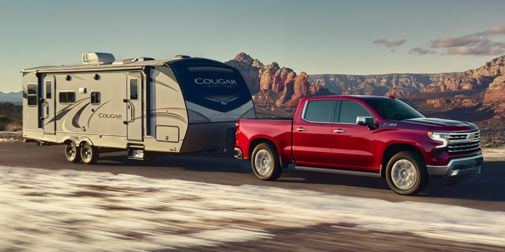 a red silverado 1500 towing a camper