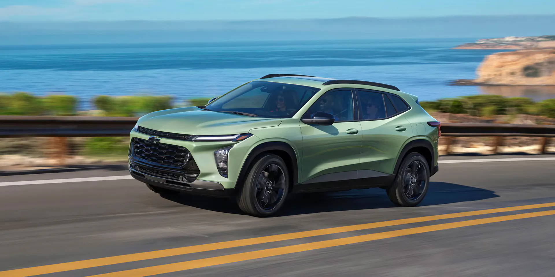 A green trax driving on the road.