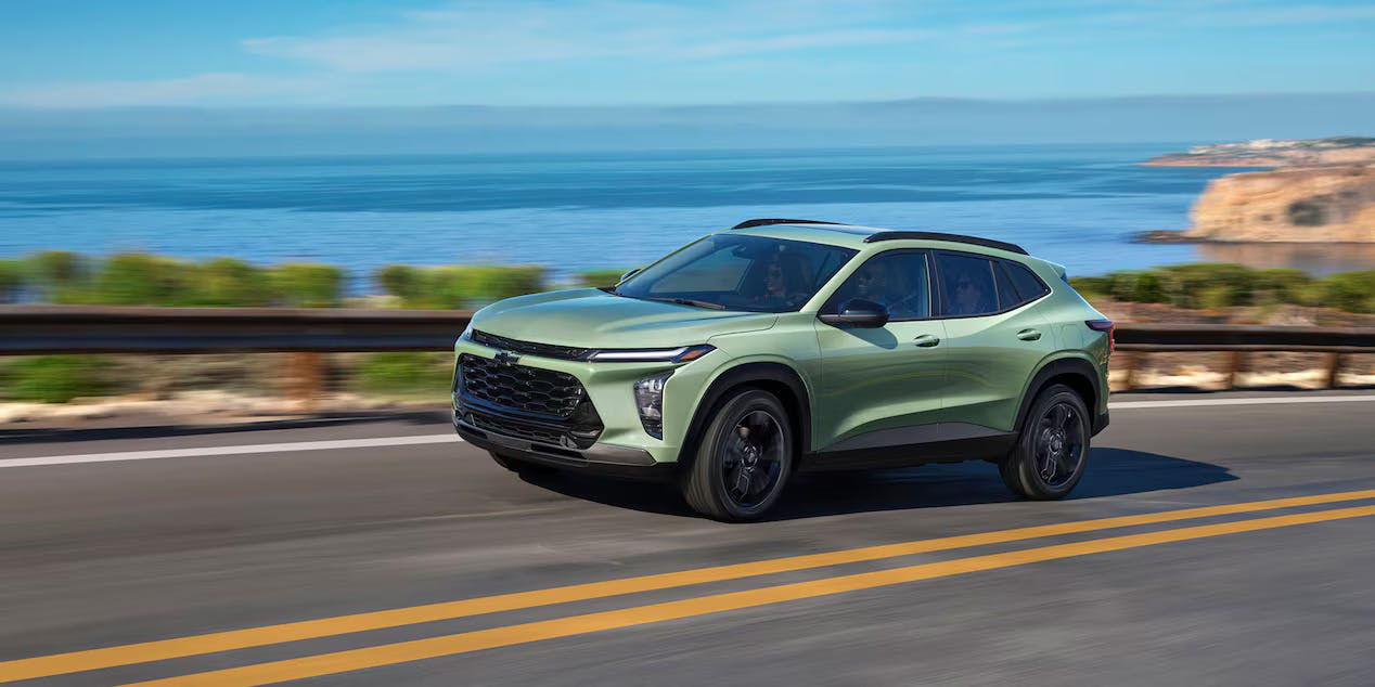 A green trax driving on the road.