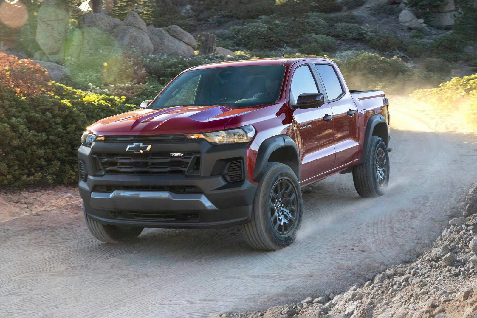 2026_chevrolet_colorado_crew-cab-pickup_trail-boss_fq_oem_2_1600x1067 A red truck driving on the road.