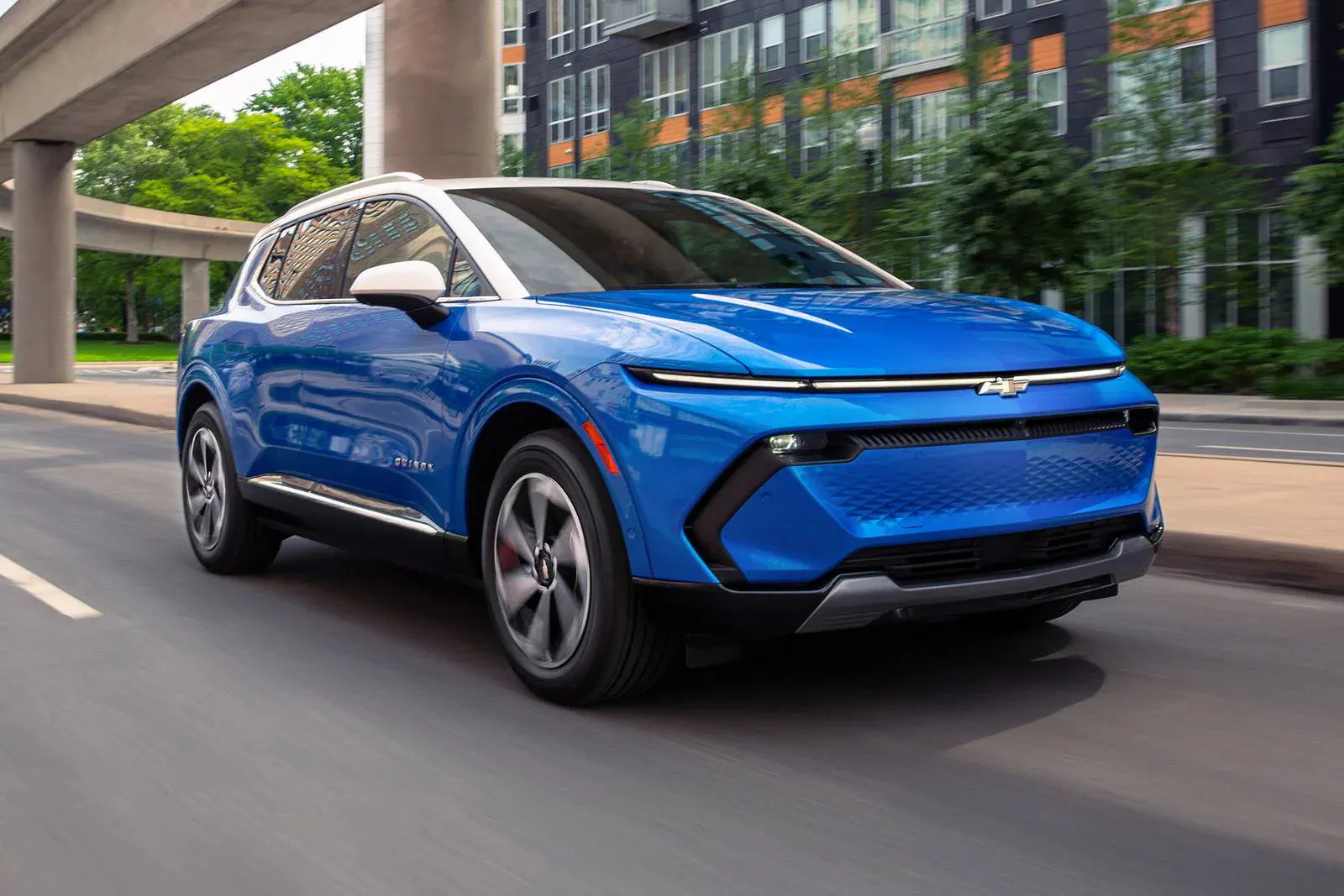 A blue equinox ev driving on the road.