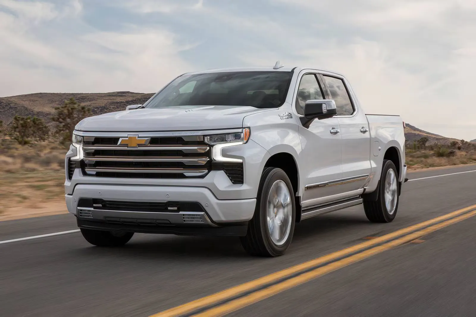 A white truck driving on the road.