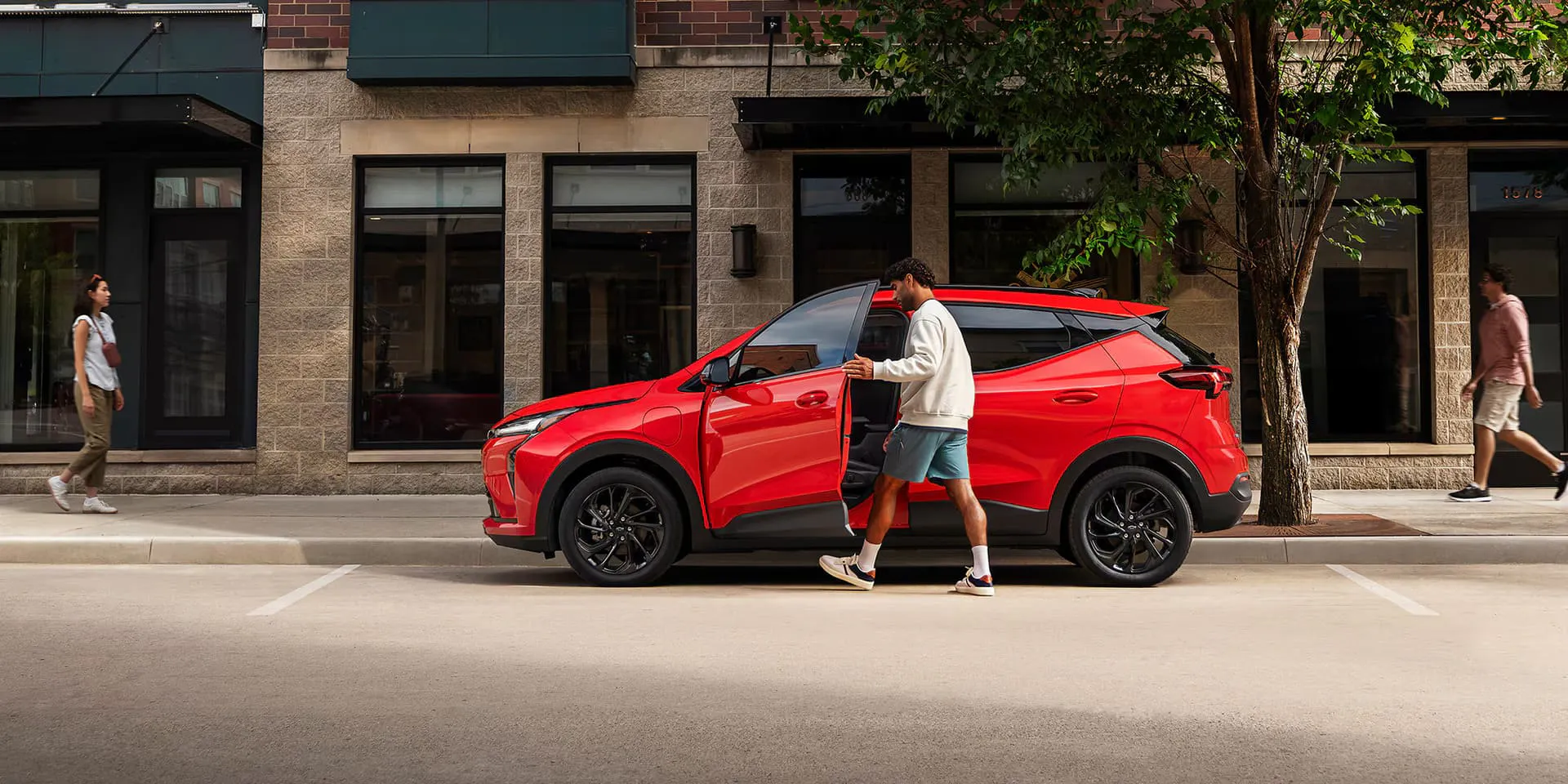 2027-bolt-ext-gal-3 The 2027 Chevrolet Bolt parked outside on a street in the city with a person getting into the vehicle