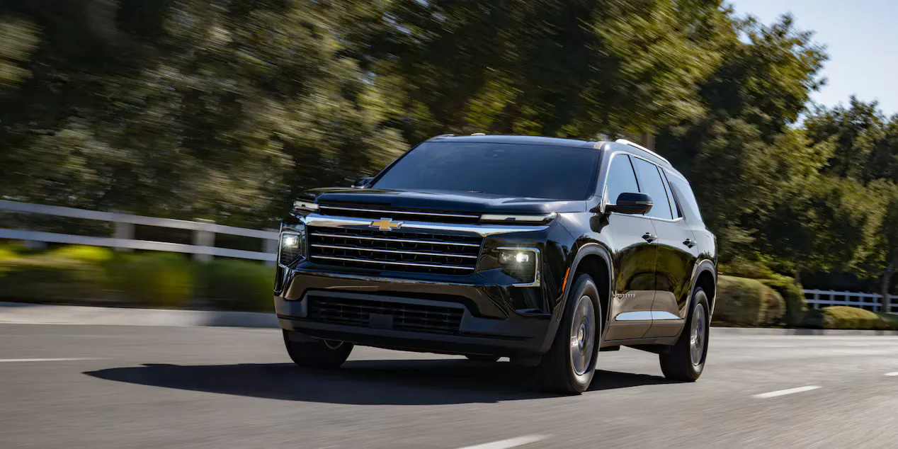 A black traverse driving on the road.
