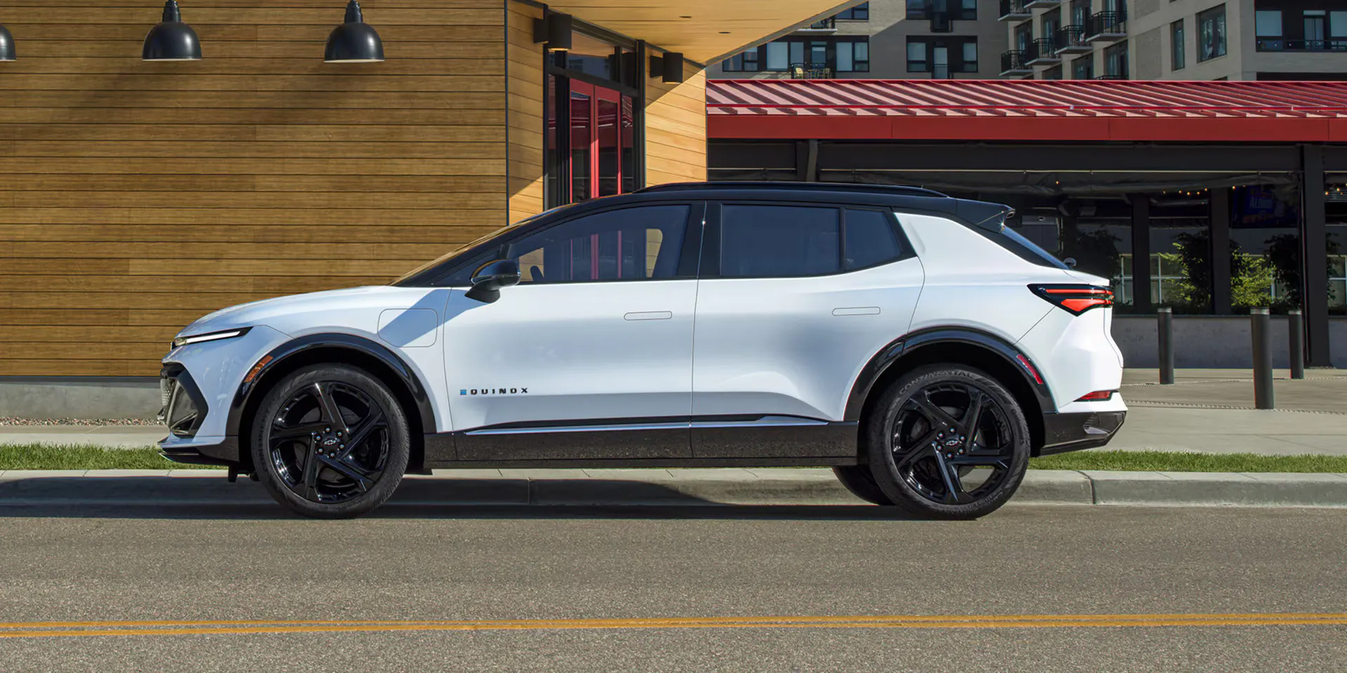 A white equinox ev sitting on the side of the road.