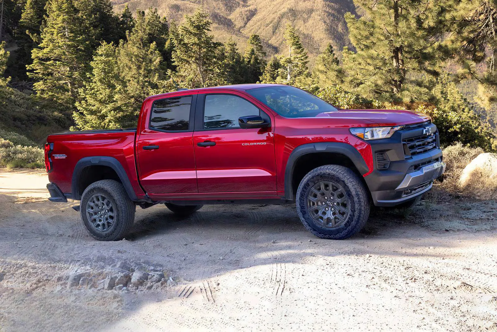 a new look at the 2026 chevy colorado driving through the forest on sandy paths