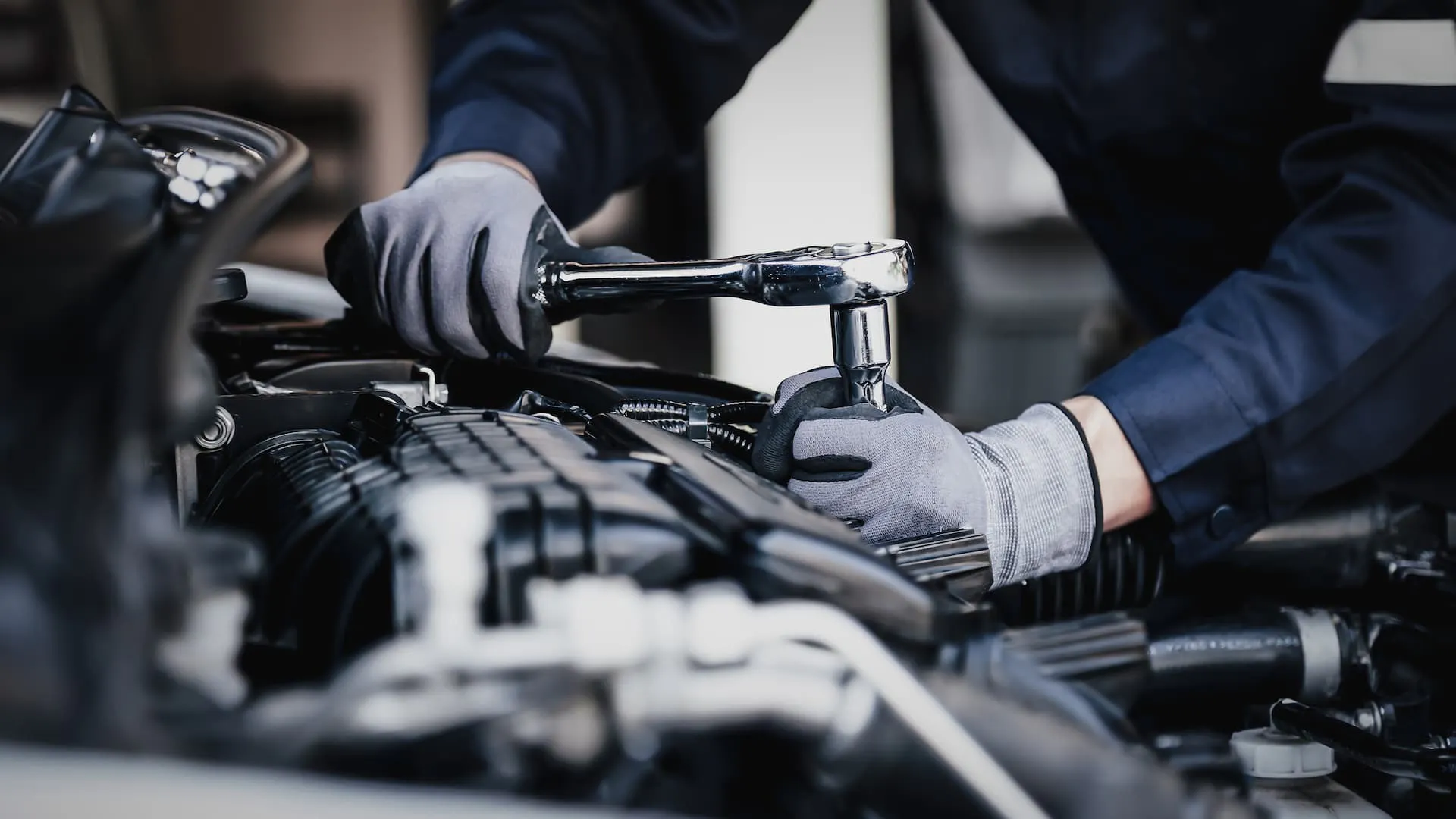 mechanic-working-on-engine A man working on the engine of a chevy vehicle.